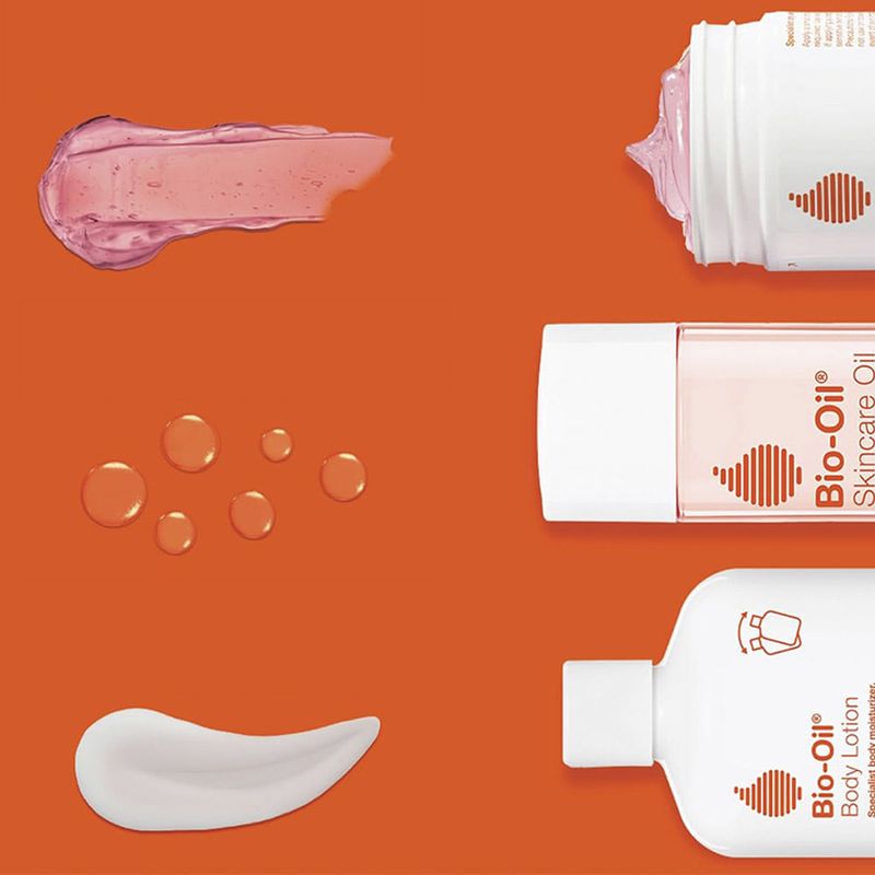 Linea-de-productos-Bio-Oil.-Aceite-para-el-cuidado-de-la-piel-gel-para-piel-seca-y-locion-corporal-con-sus-texturas-en-fondo-naranja.-Productos-para-hidratacion-y-cuidado-de-la-piel