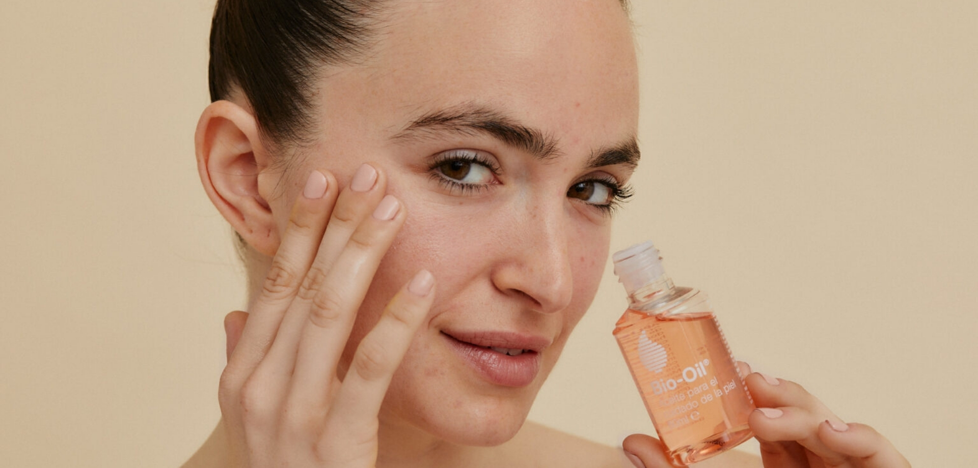 Mujer cuidando su piel del rostro mientras se aplica el aceite Bio-Oil