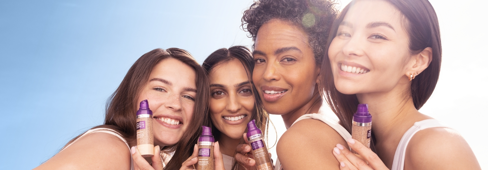 Mujeres de diferentes raíces sosteniendo maquillaje híbrido en sus manos mientras sonrien